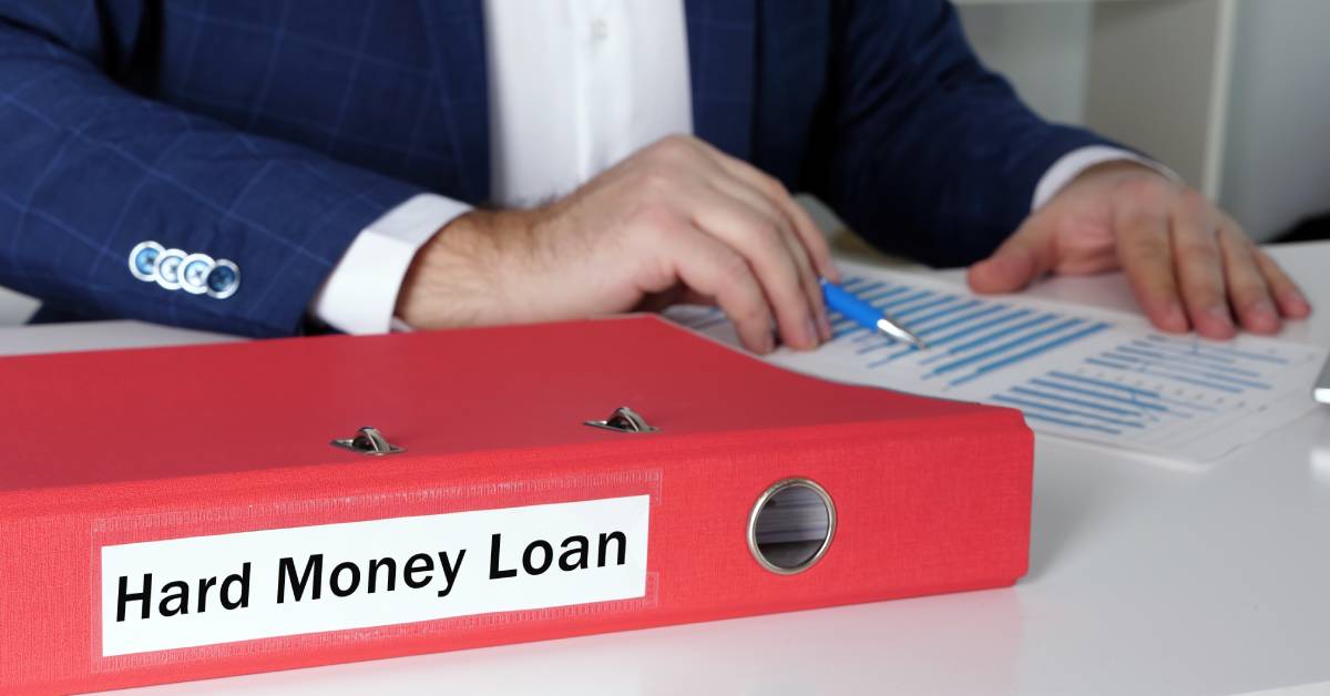 A businessman looking over financial documents next to a binder labeled 