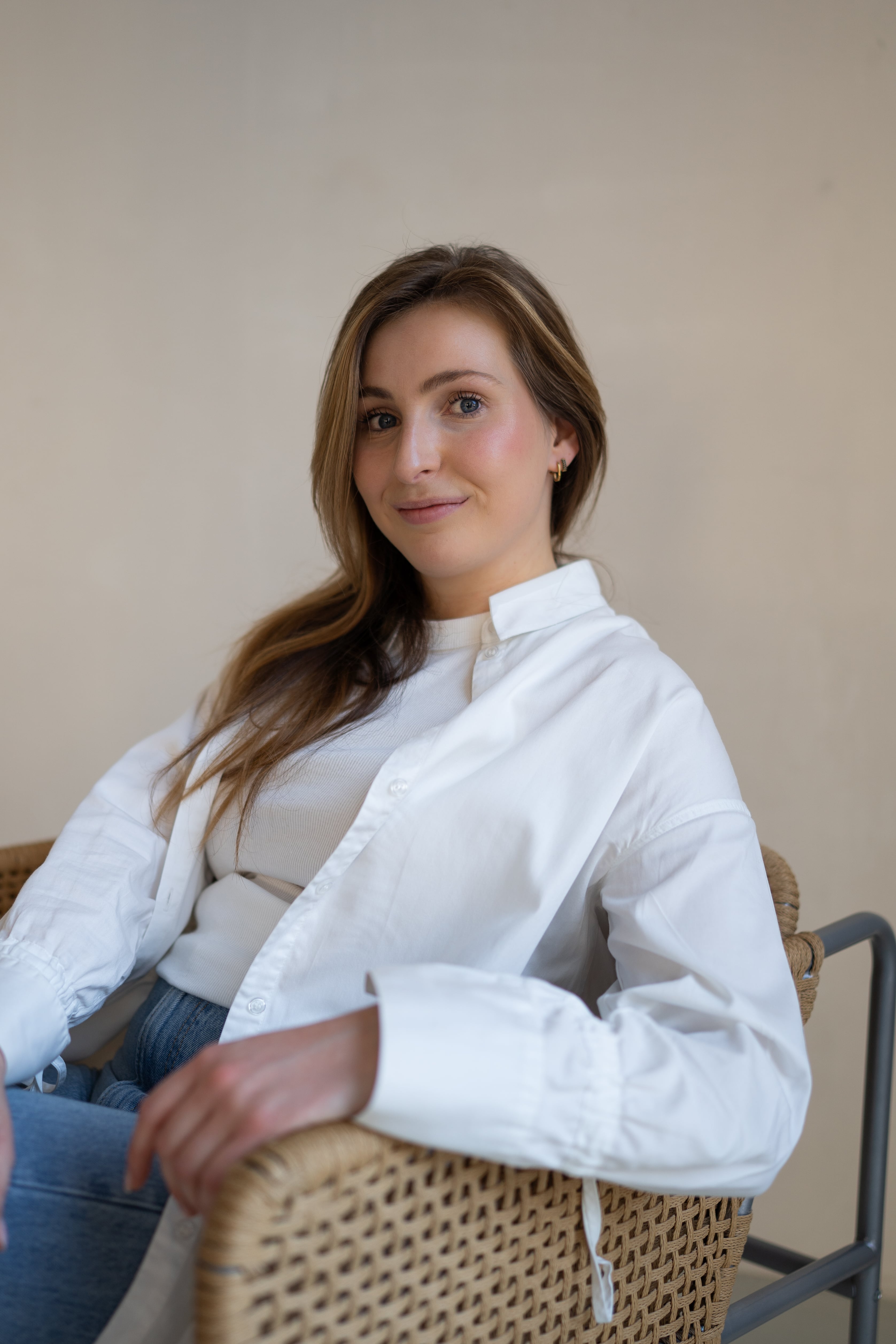Photo of Emma sitting in a chair and smiling in the camera