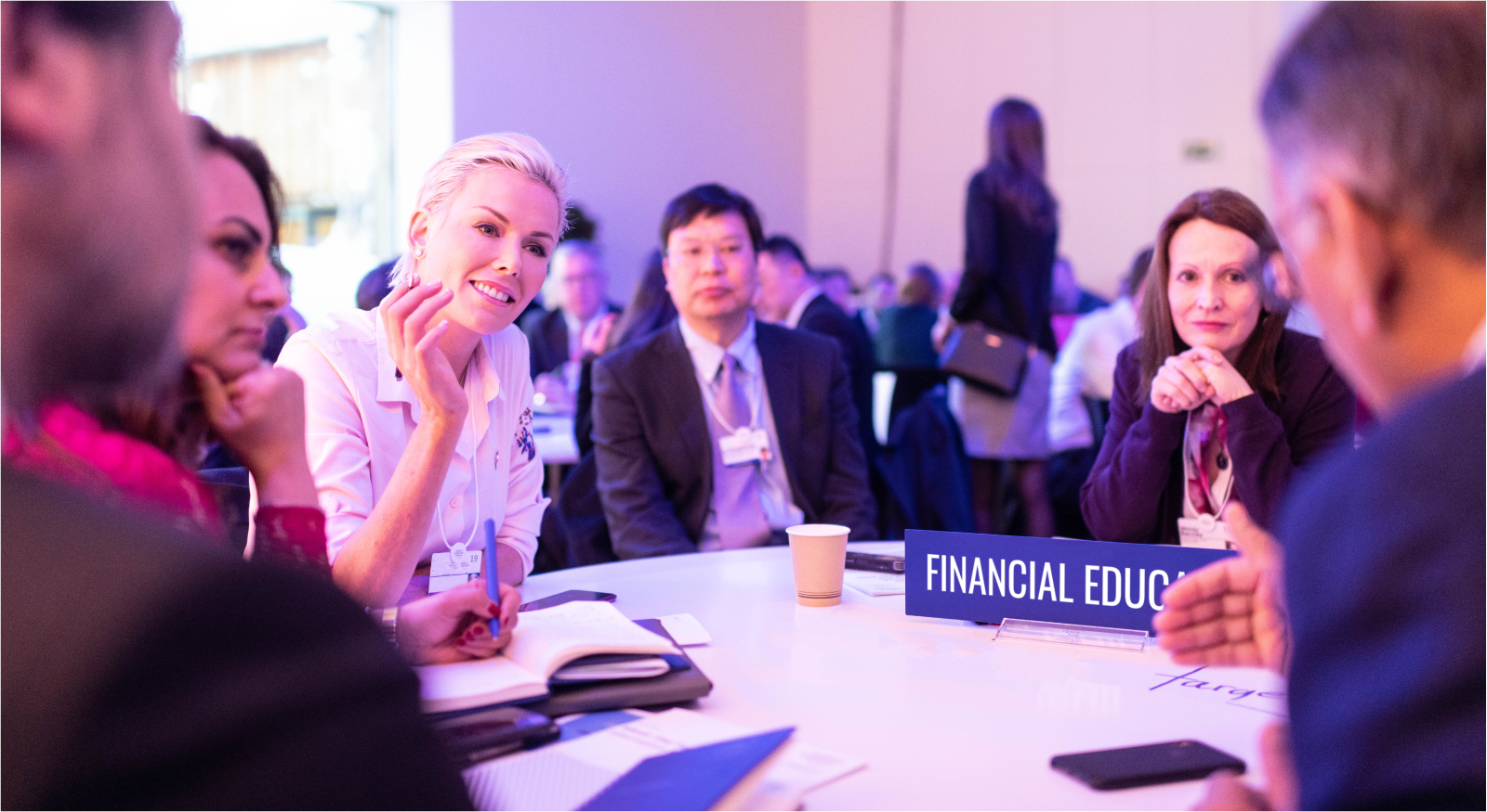 A photo of a group of diverse individuals discussing finance at a conference