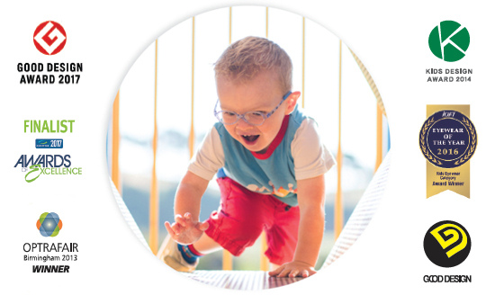 Smiling young boy wearing glasses crawling through a play tunnel with award logos around.