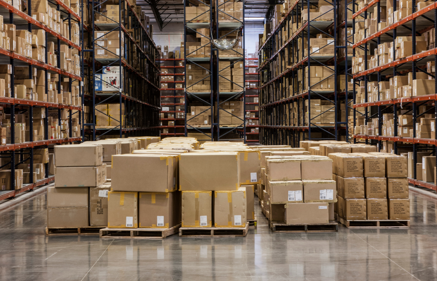 Pallets of boxed inventory stored on industrial warehouse shelving