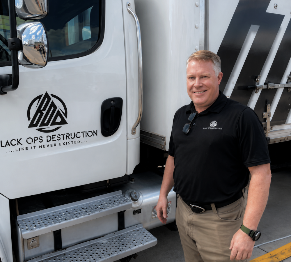 Black Ops Destruction team member standing beside a secure document shredding truck in Ohio