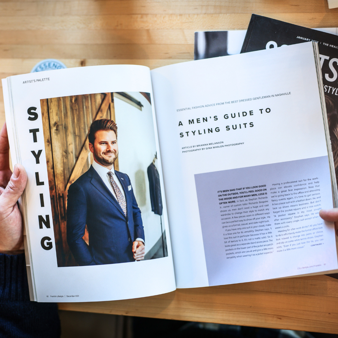 An open magazine turned to an article titled "A Men's Guide to Styling Suits," with an image of a caucasian male in a blue suit.