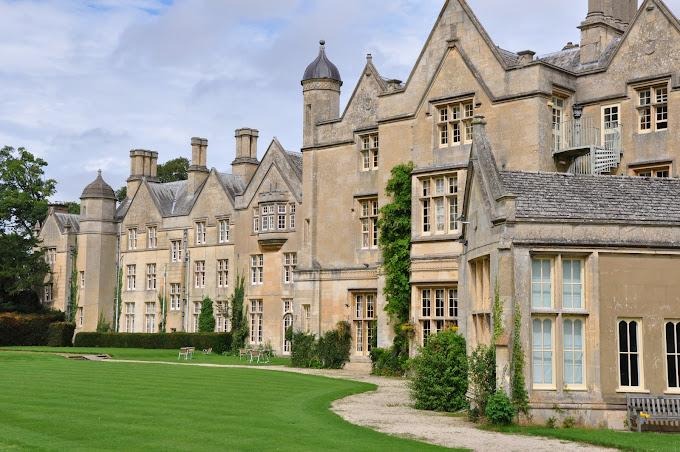 A large stone building with a lawnDescription automatically generated