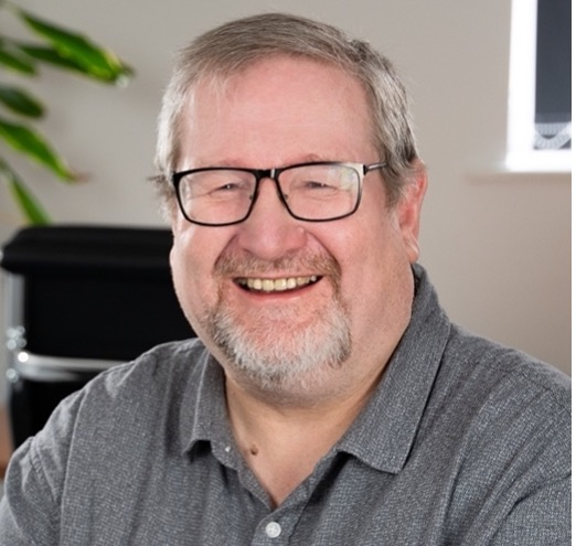 A person wearing glasses and a grey shirtAI-generated content may be incorrect.