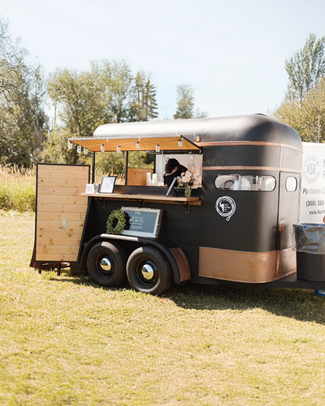 The Round Up Mobile Bar, a dry bar for hire in Whatcom County, parked in a field at an event.