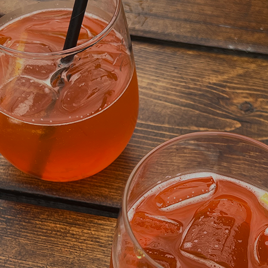 Orange mixed drinks sitting on a wooden surface