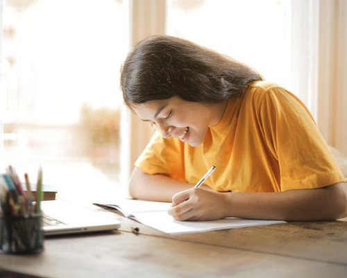 student taking notes while at home