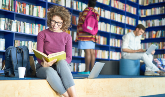 female student reading book in library