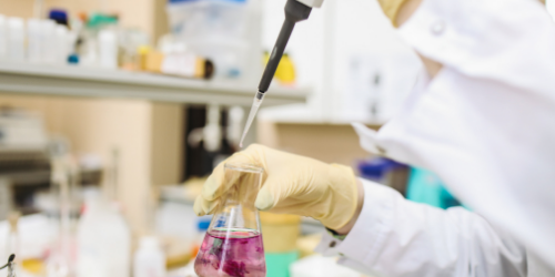 scientist holding beaker in lab