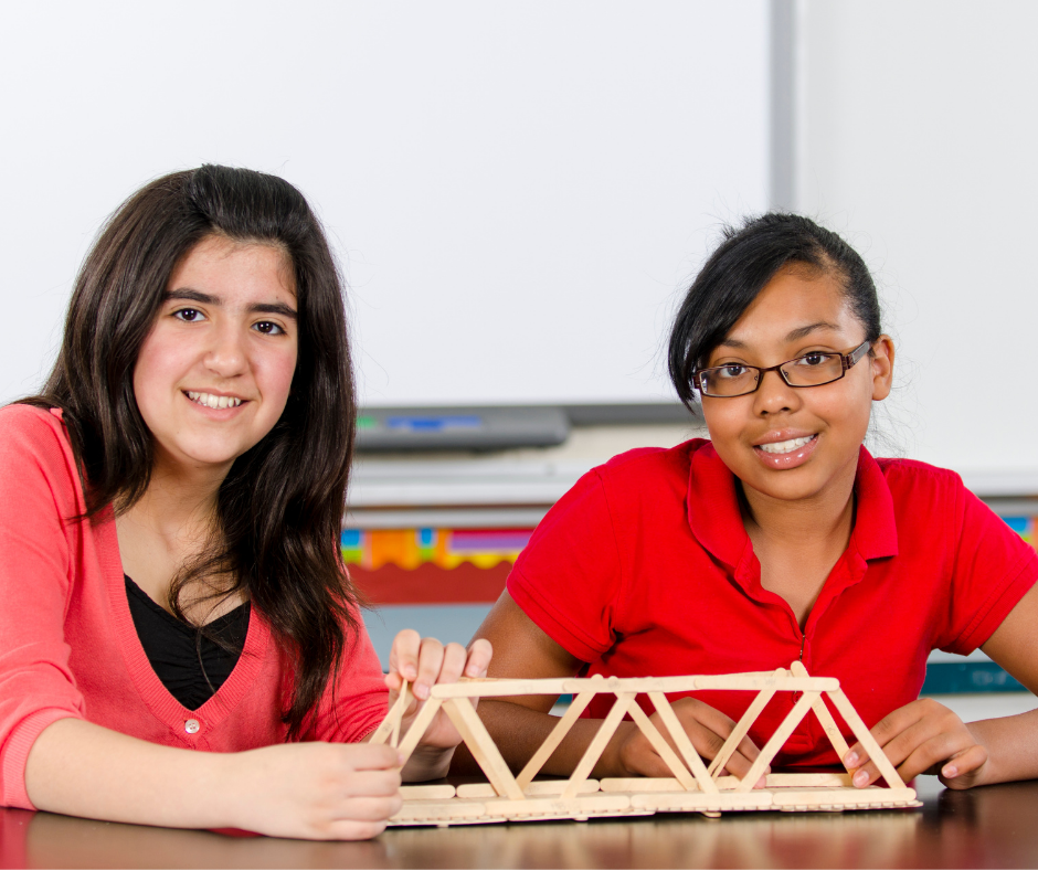 female students building wooden bridge in class
