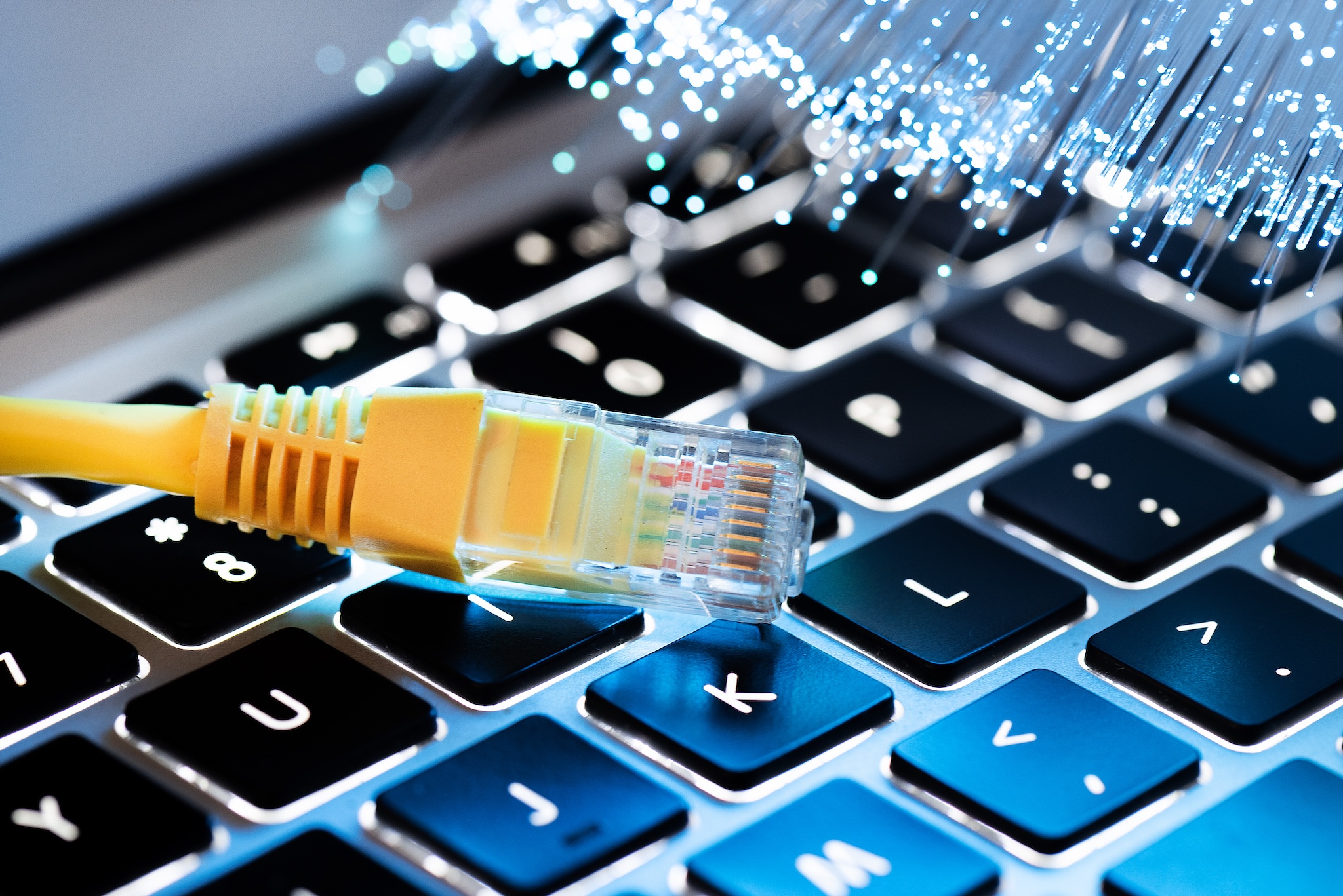 Fibre optics and a telephone cord displayed over a laptop keyboard