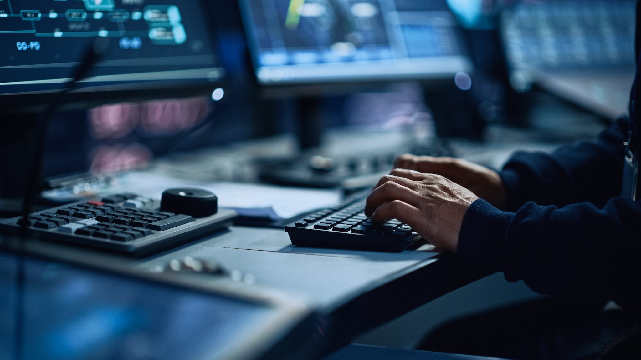 Close up photo of someone typing on a keyboard, you can see a bit of the computer monitor
