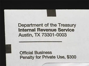 Close-up of an official IRS envelope from the Department of the Treasury in Austin, Texas, addressed for official business with penalty notice.