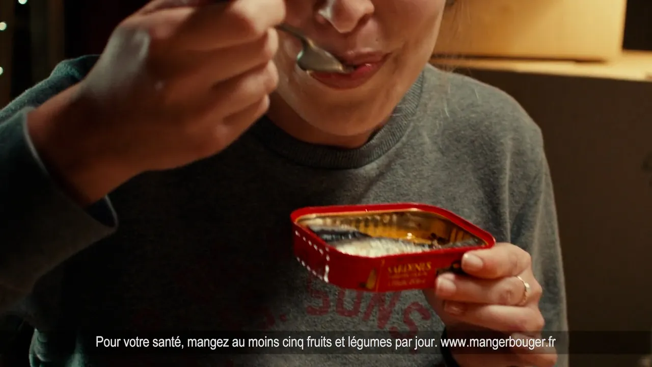 Femme qui mange une boîte de sardines