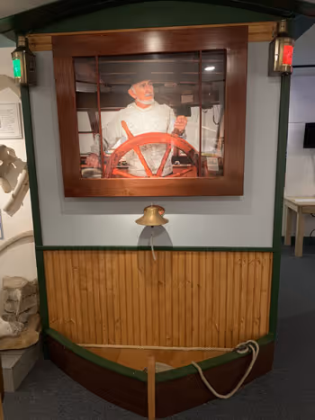A picture of a man on a boat in a museum.