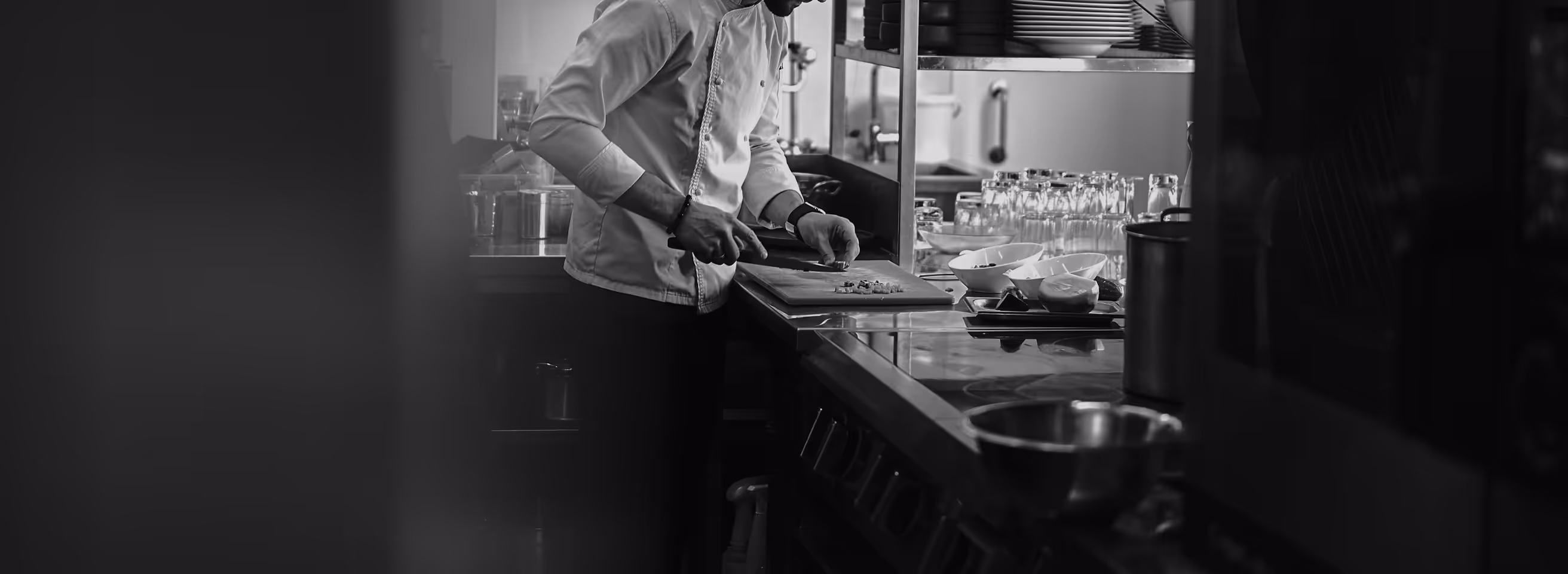 Chef preparing food at a counter in a professional kitchen