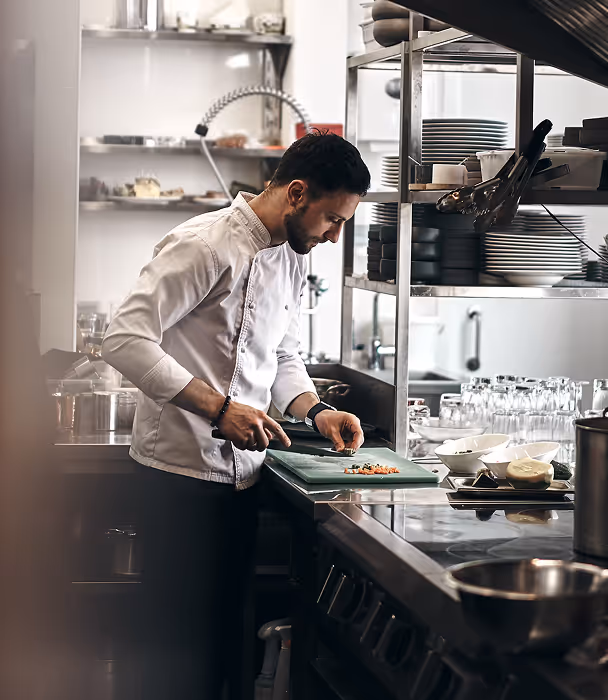 Chef preparing food in a professional restaurant kitchen