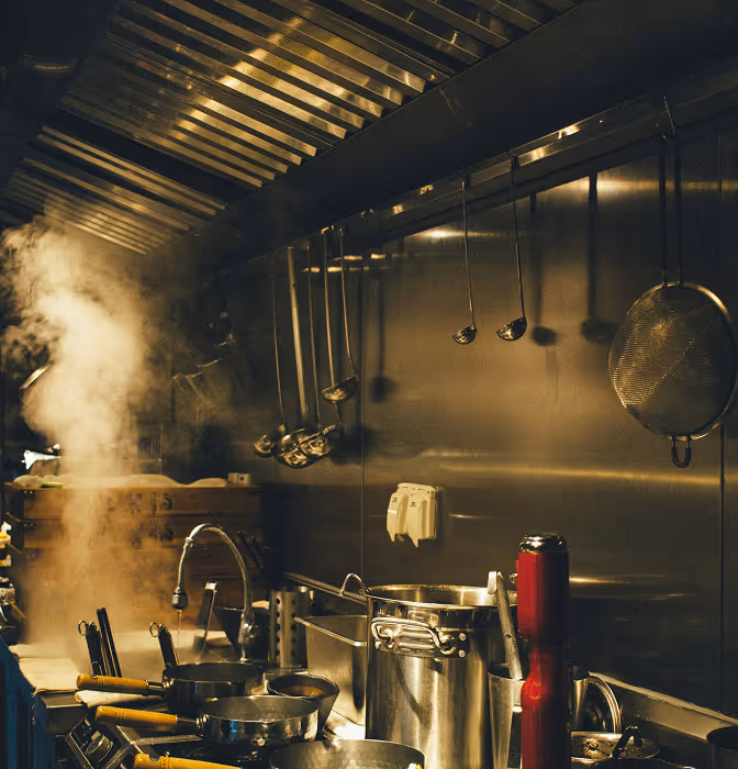 Commercial kitchen interior with stainless steel equipment and cooking utensils