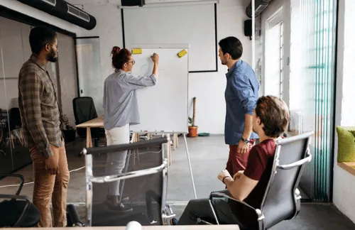 Team members in a workshop around a whiteboard