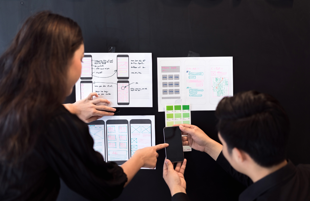 Creative ux designer team planning application for mobile responsive website development with UI/UX