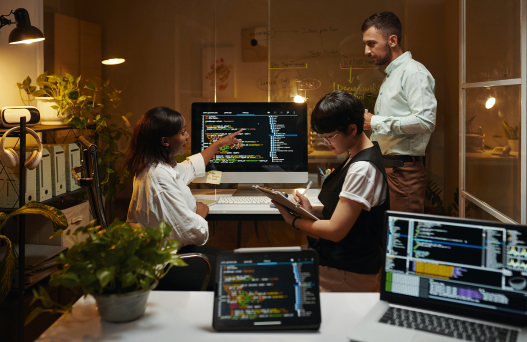 Team of people discussing code at a computer