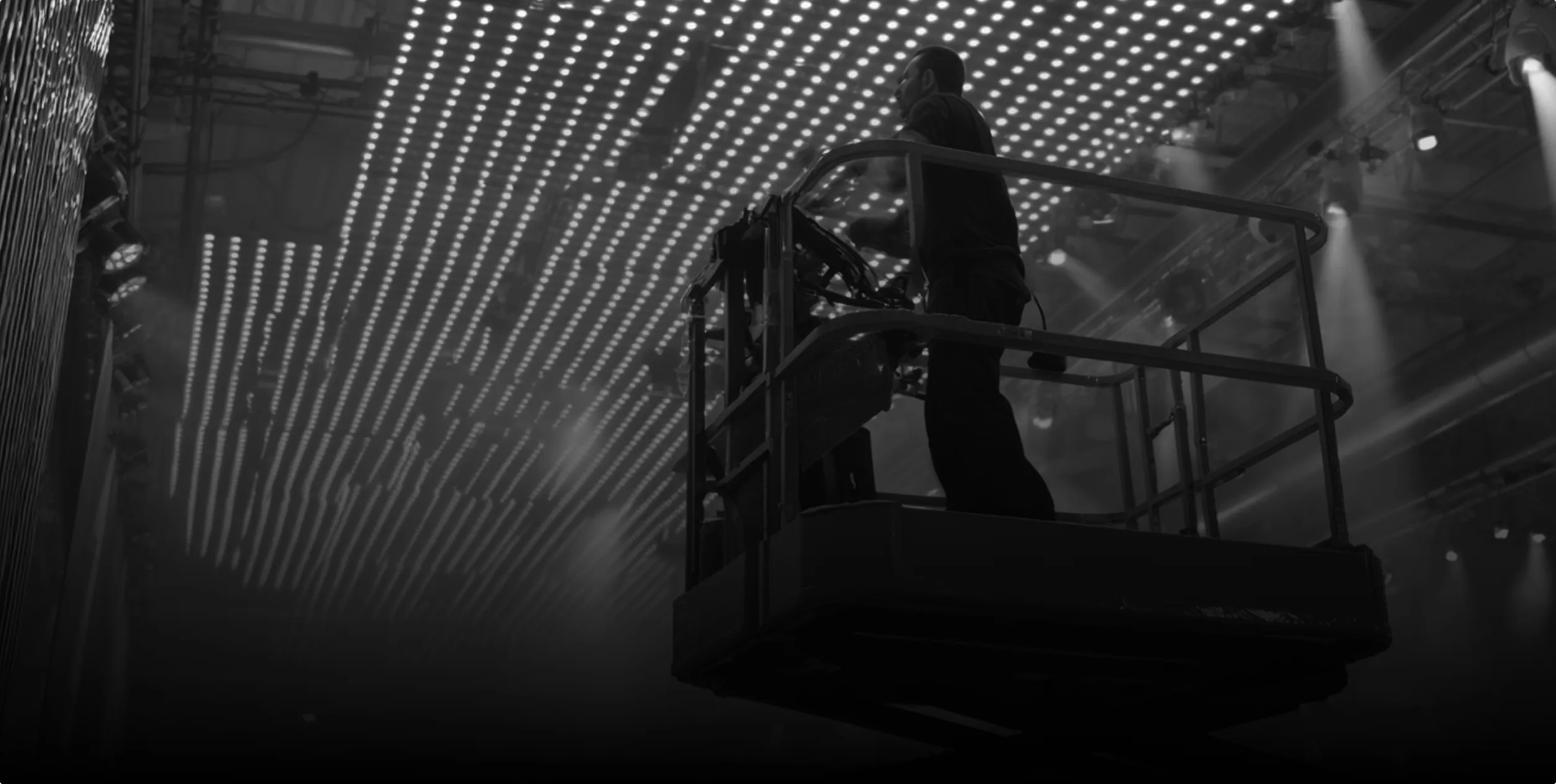Technicien procédant à l’installation de matériel audiovisuel professionnel dans un espace dédié, avec précision et câblage structuré.
