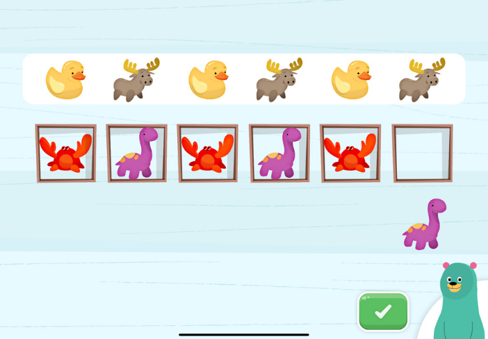 Smiling teacher helping a young student build english language skills with Khan Academy Kids.