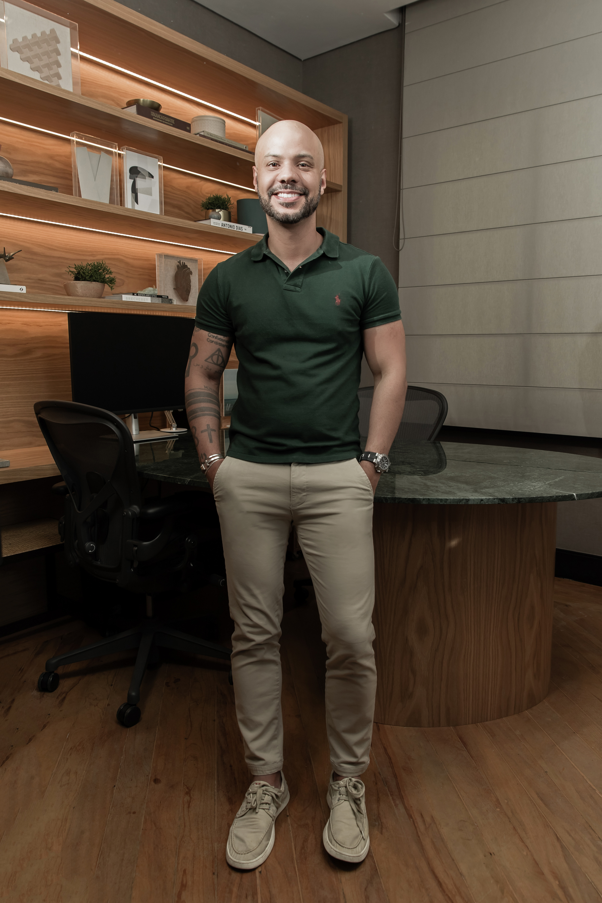 Fernando Barros, CEO da Ambienta Casa, com uma camisa verde e uma calça bege. 