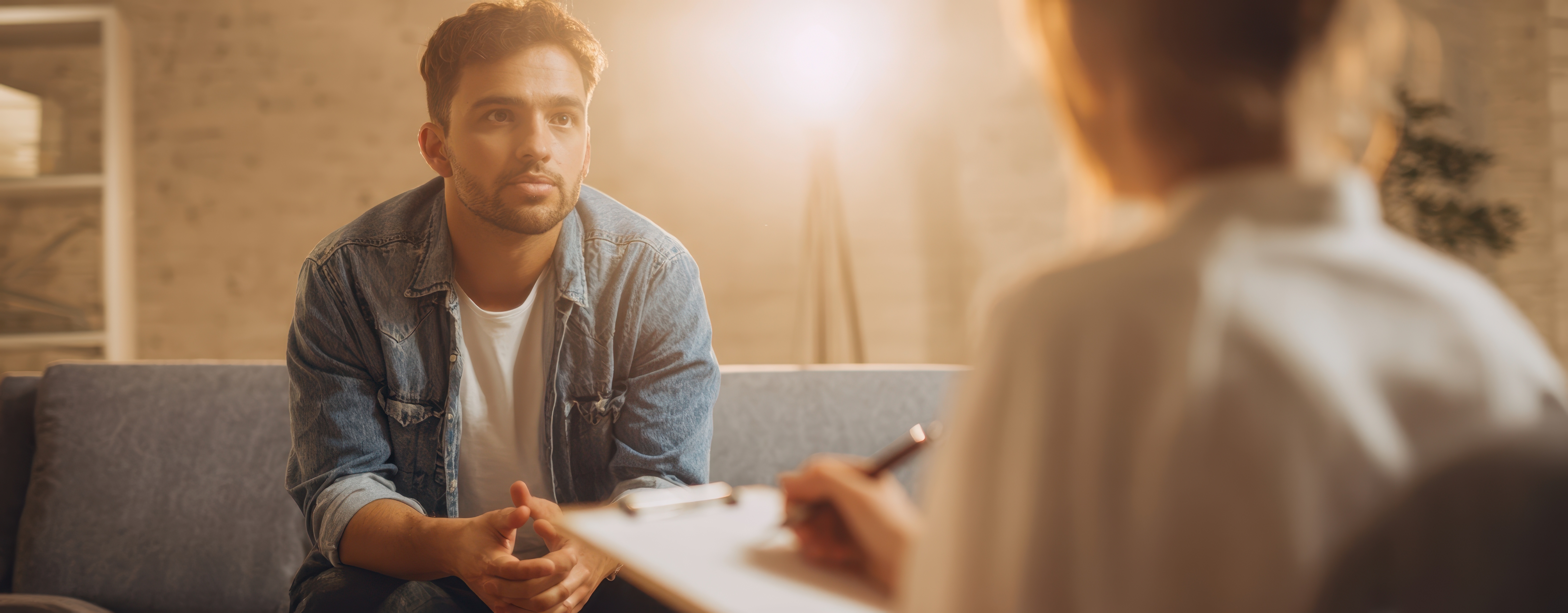 Man talking with a professional during a one-on-one support session, representing the difference between coaching and therapy.
