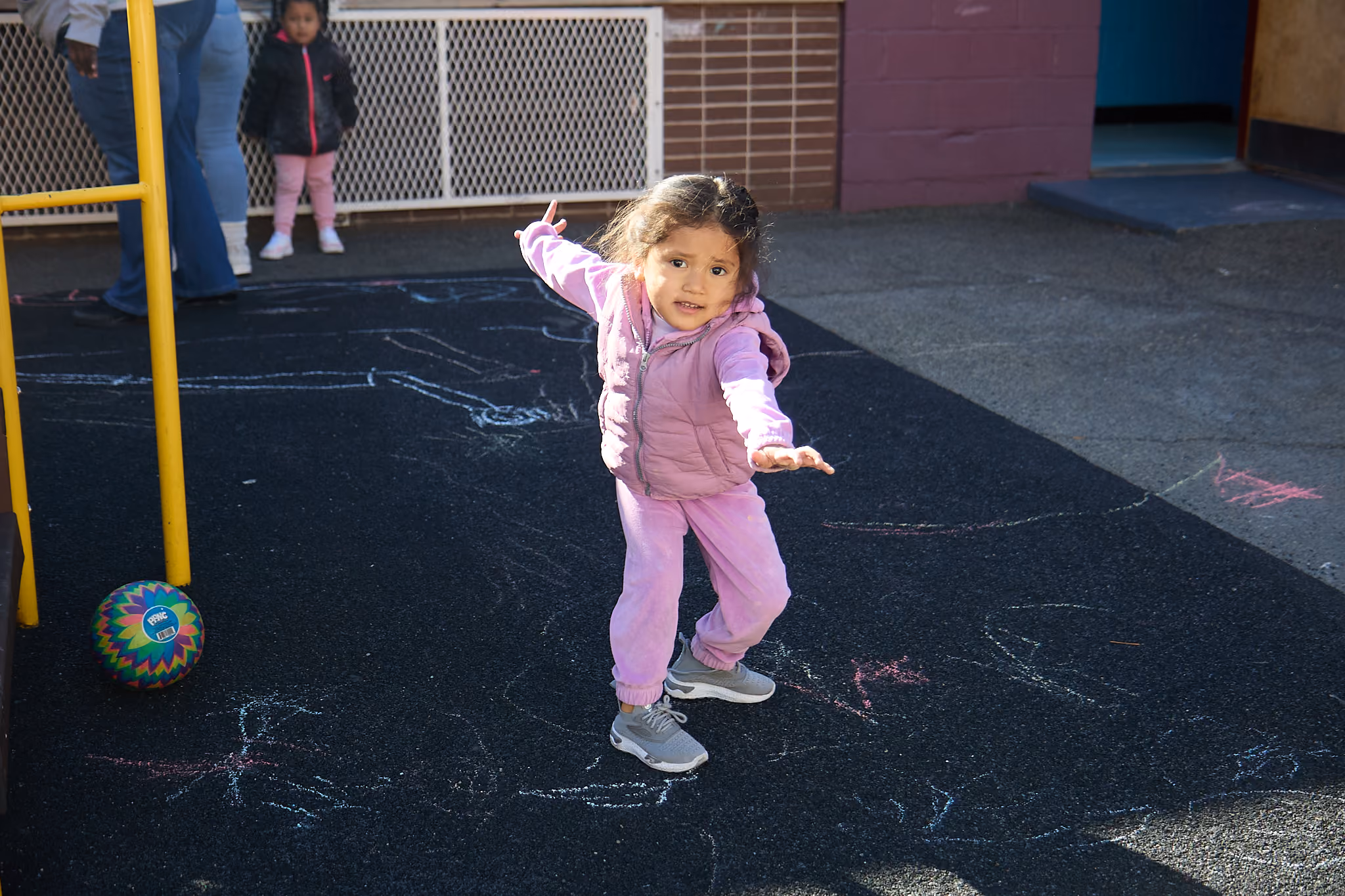 Young student drawing with chalk on playground during outdoor activity