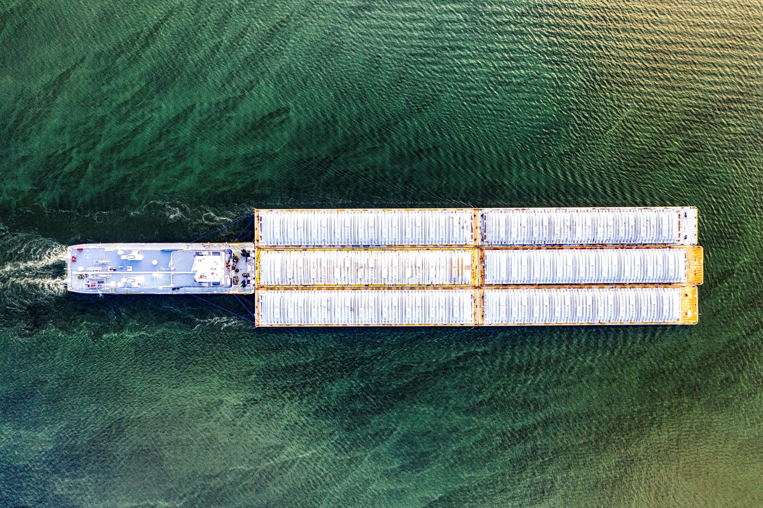 A pusher tug pushing a barge with containers