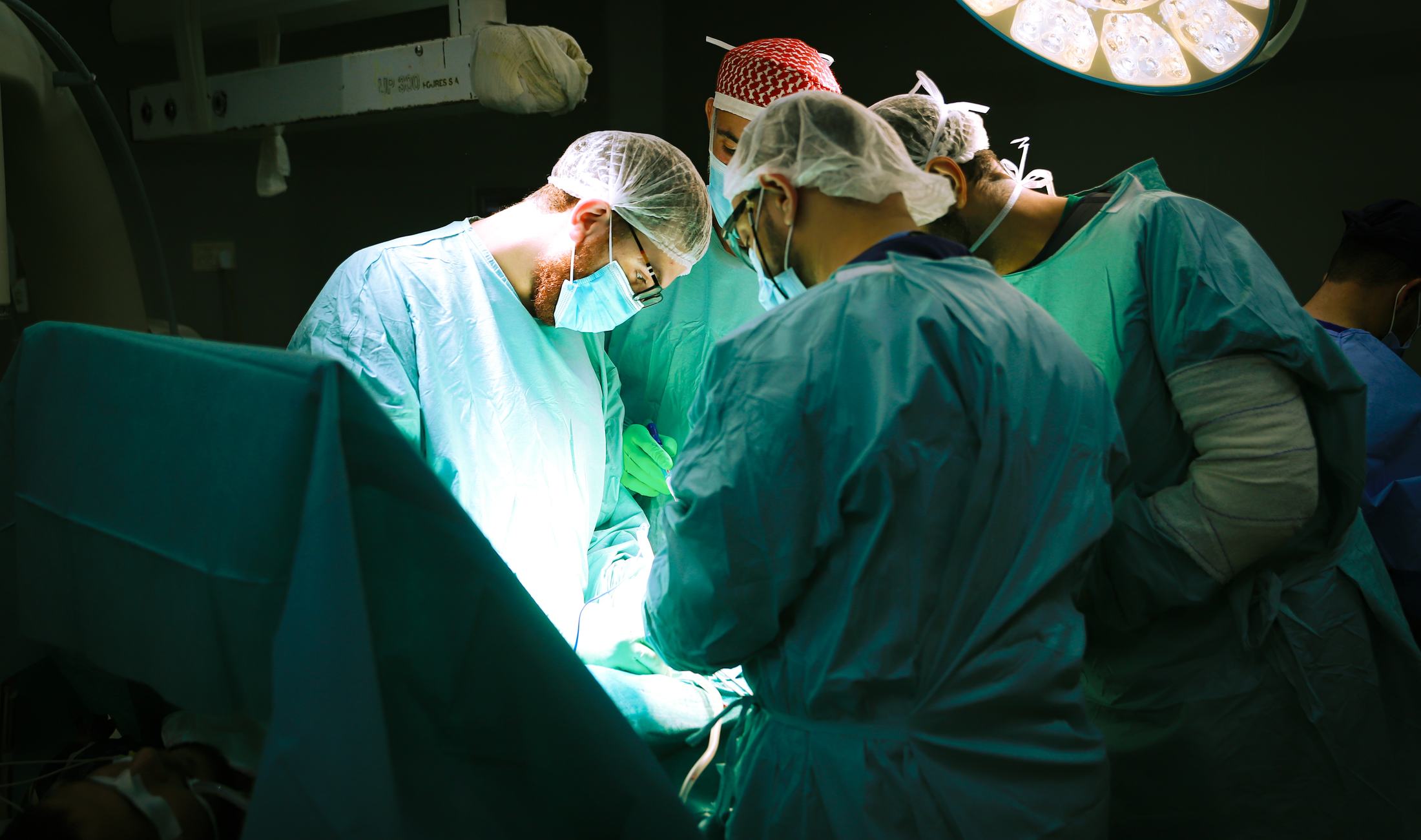 A FAJR Global surgical team operating under theatre lights during a mission.