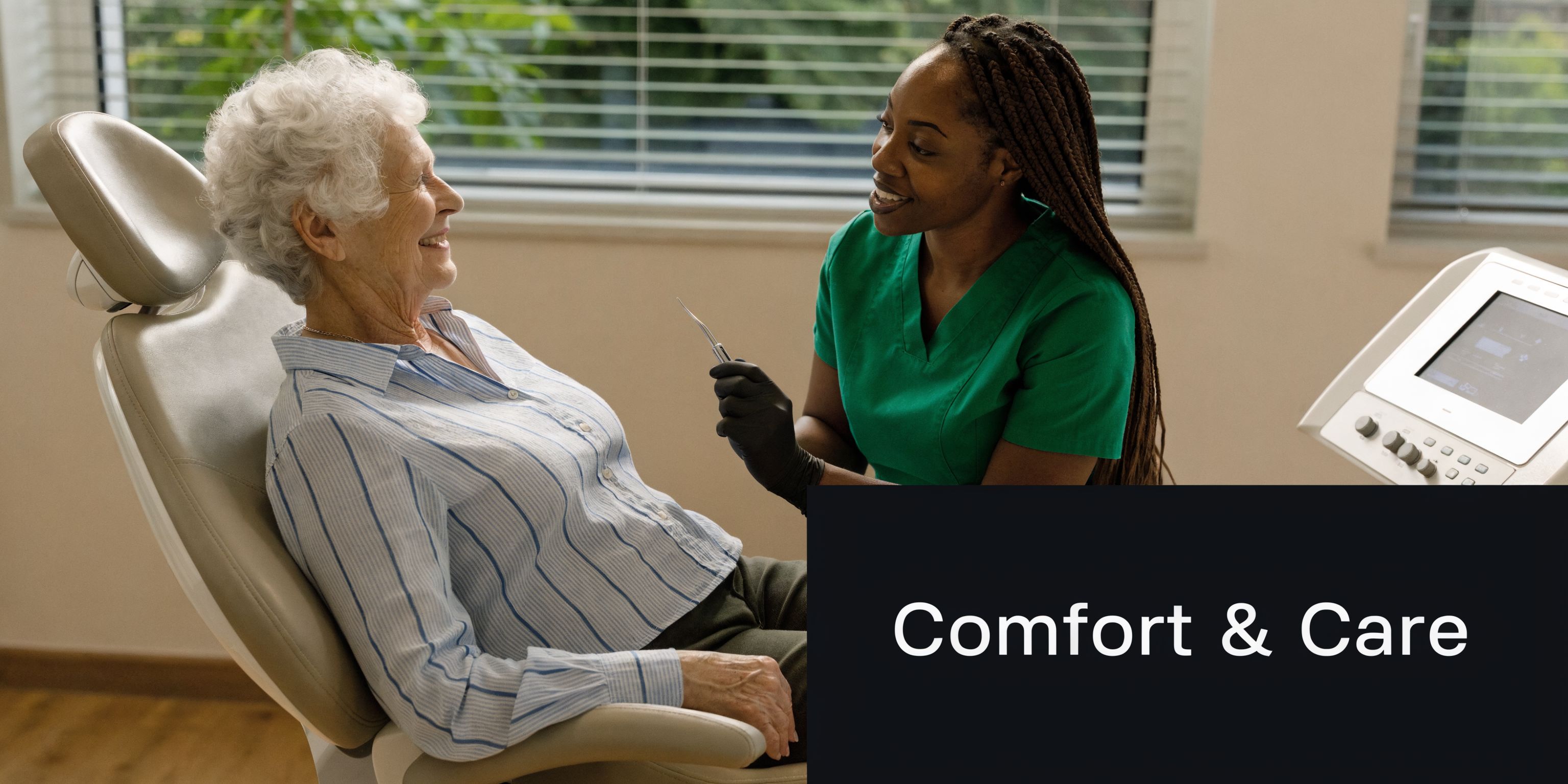 A friendly dental professional smiling while consulting with an elderly female patient in a dental clinic chair.