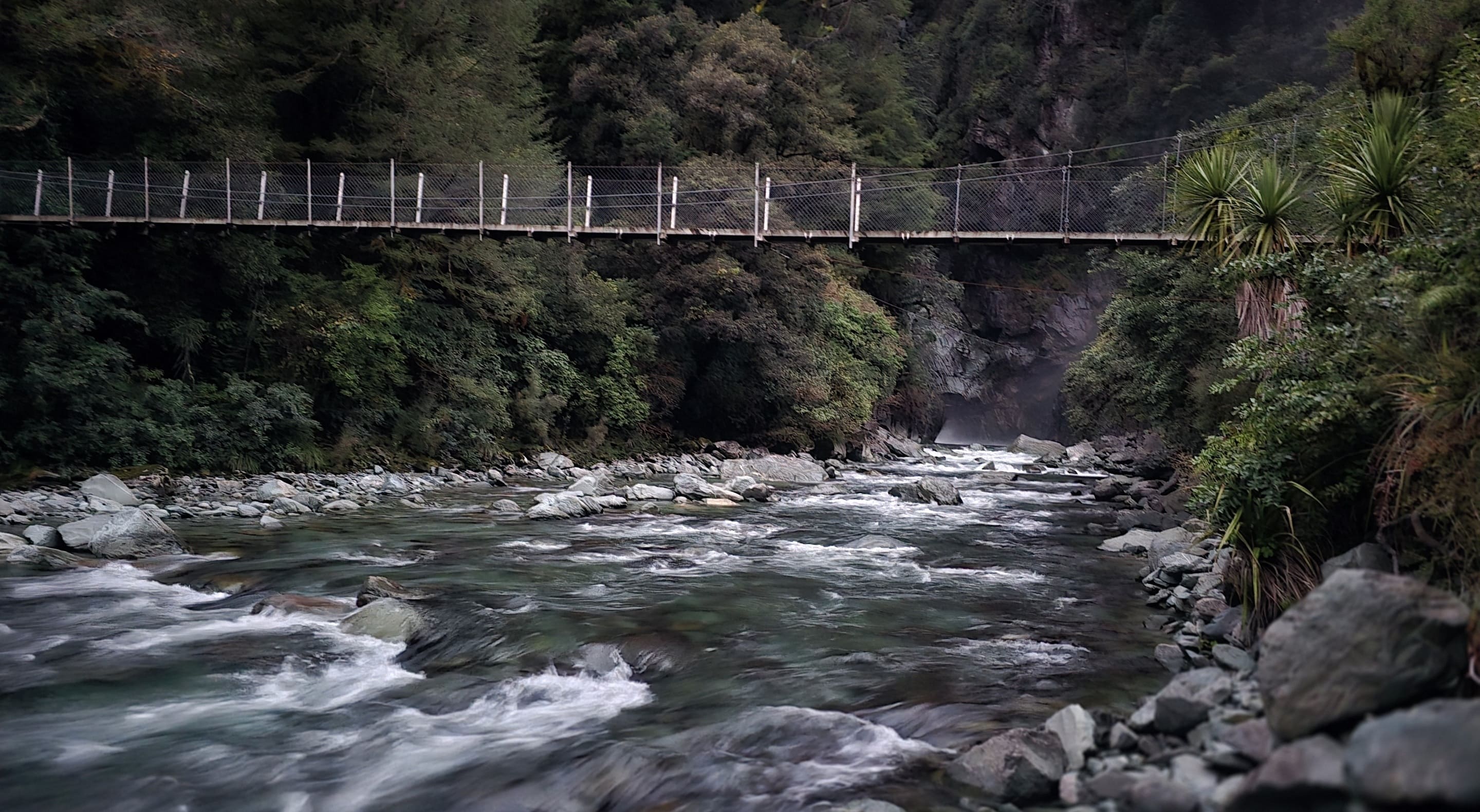 An wire footbridge over a wild river