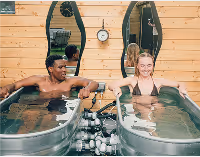 Two guests enjoying cold plunge therapy in side-by-side tubs at Sásta Saunas, promoting recovery in Leixlip, Kildare.