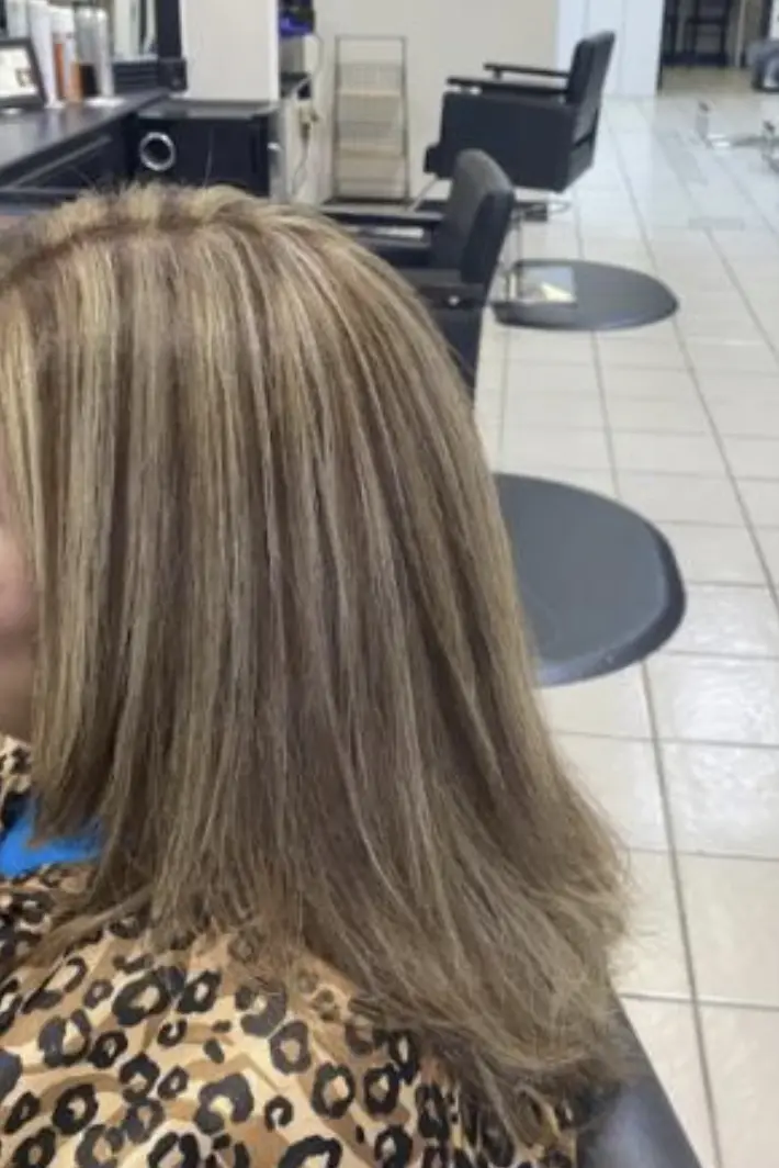 After styling: medium-length brunette hair with creamy blonde highlights, loose waves cascading down the back.