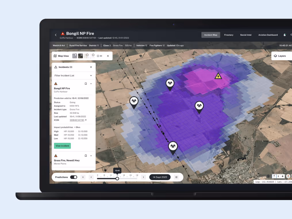 A laptop screen displaying a fire prediction map with a purple heat zone over a rural area, marked with icons indicating points of interest or alerts.
