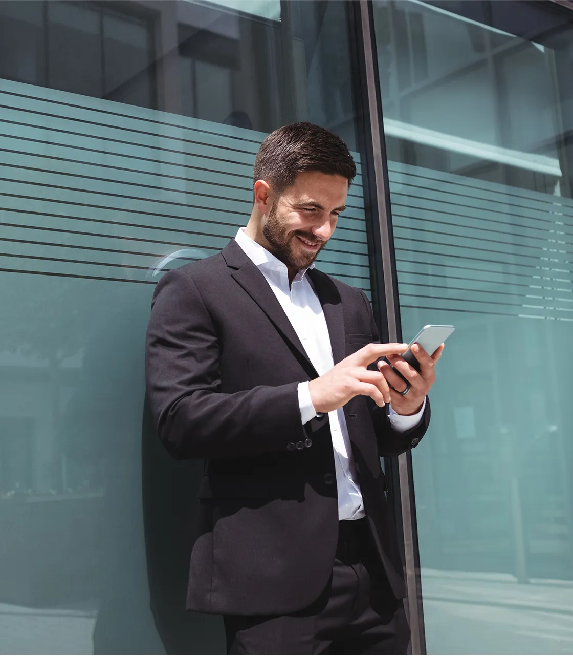 A man in a suit looking at his cell phone.