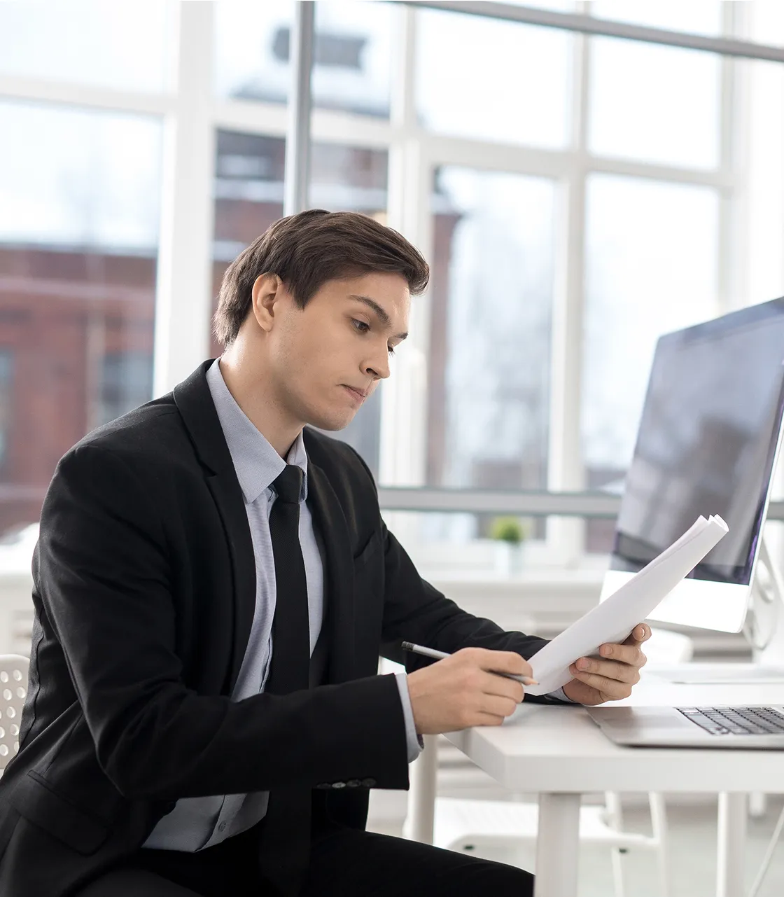A man in a suit sitting at a desk.