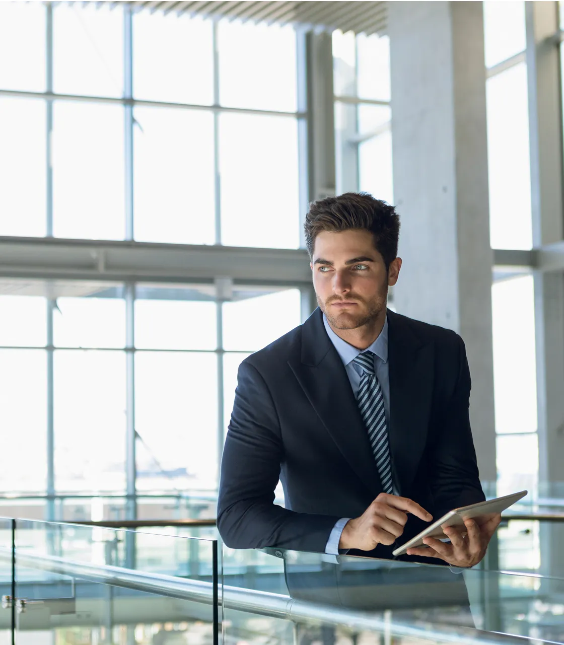 A man in a suit and tie sitting at a railing.