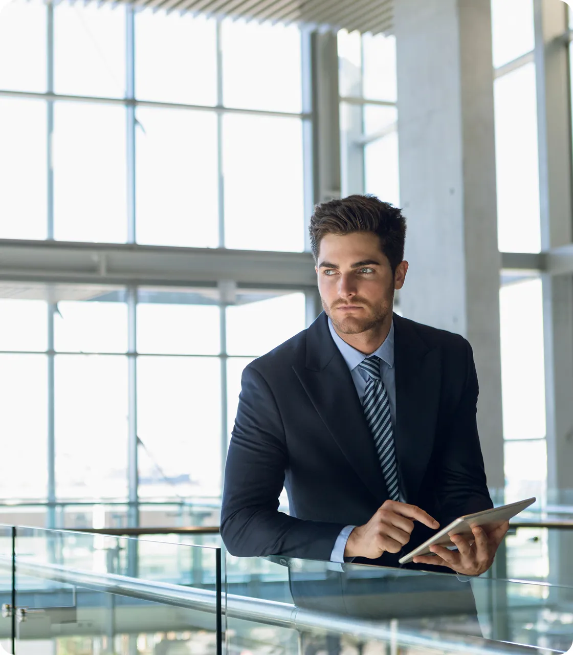 A man in a suit and tie sitting at a railing.