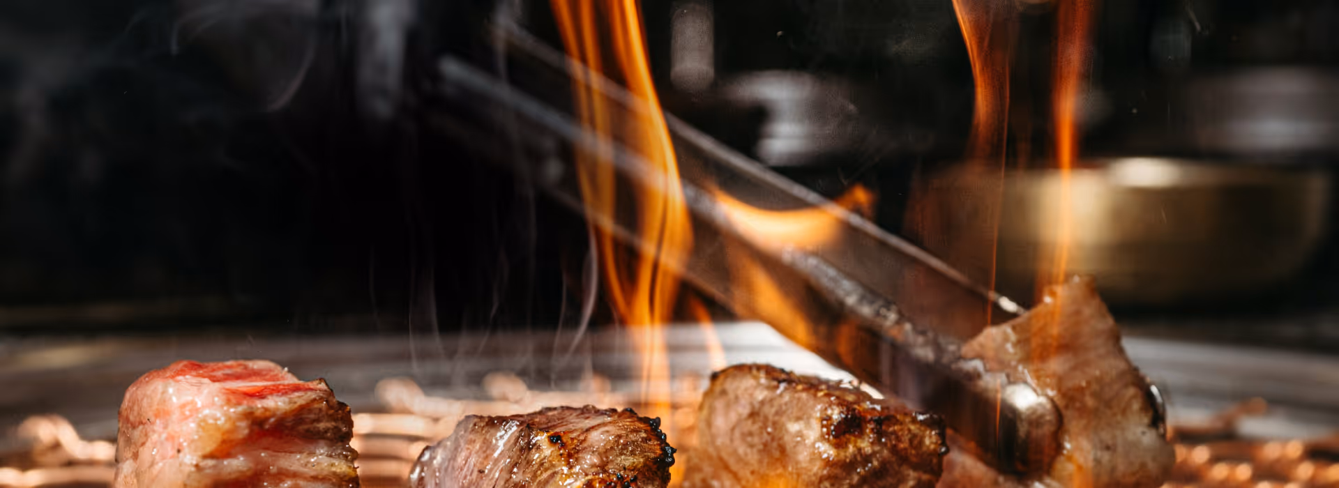 Cuisson de viande au barbecue coréen avec flammes vives et pince métallique
