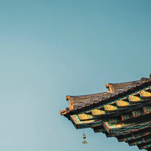 Avant-toit décoré d’un temple traditionnel coréen, orné de motifs dancheong multicolores sous un ciel bleu