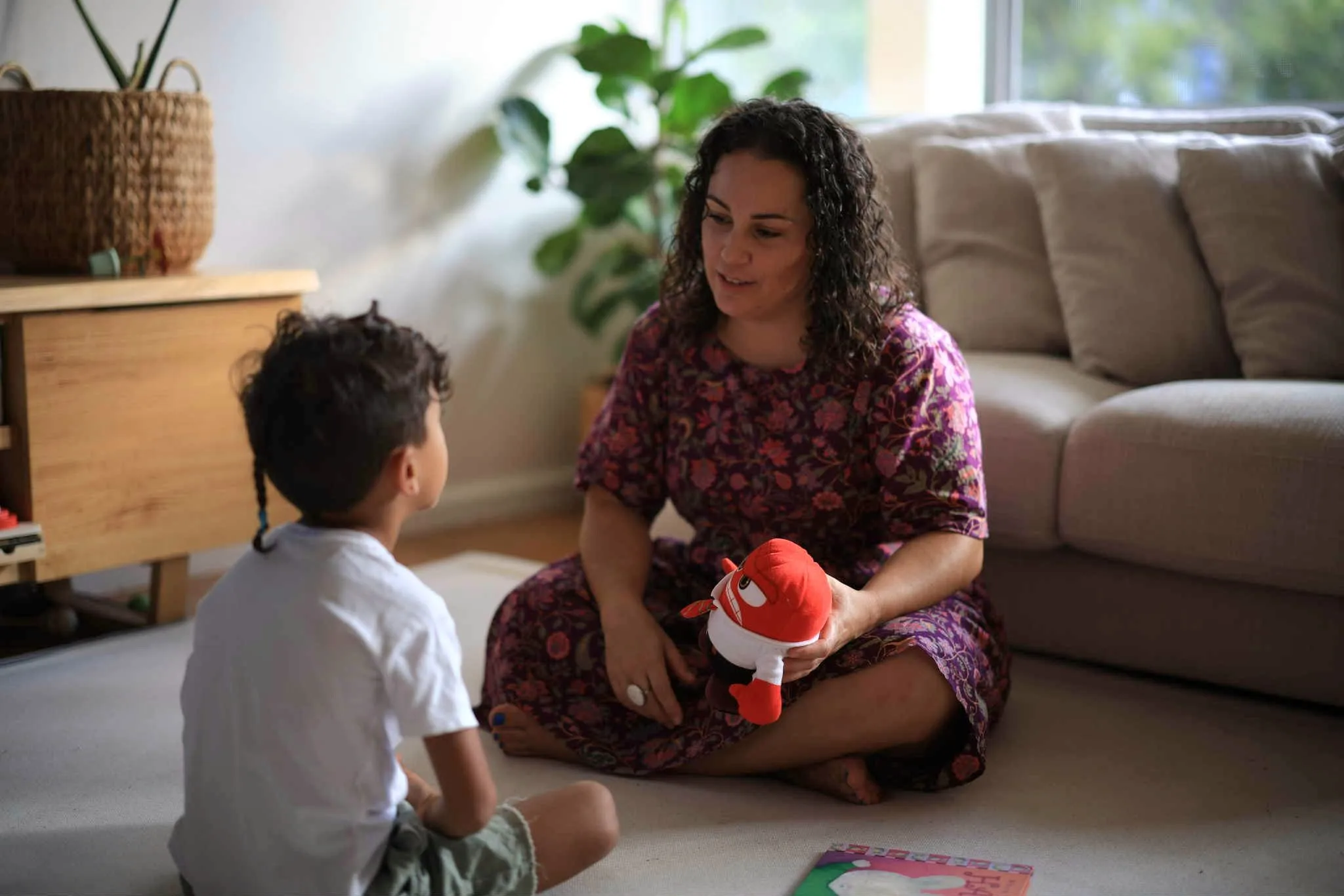 A woman sitting on the floor playing with a child.