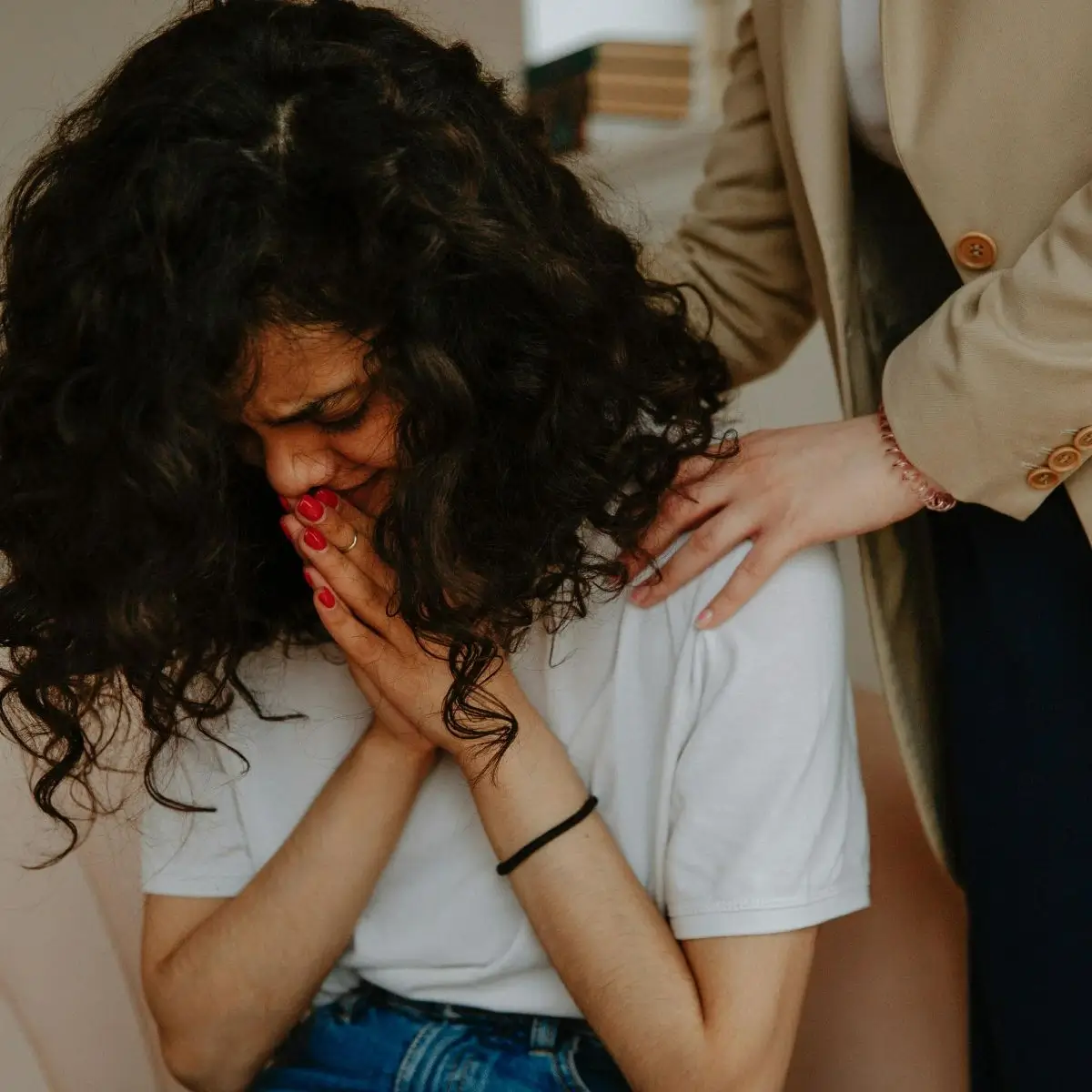 A woman covering her face with her hands.