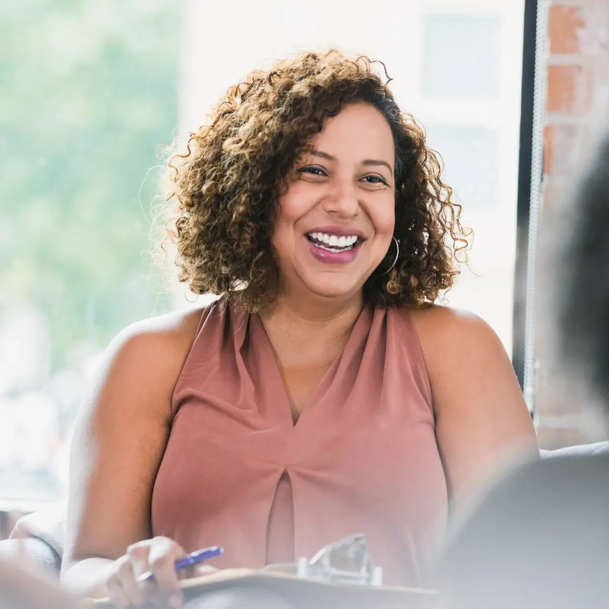 A woman sitting at a table with a smile on her face.