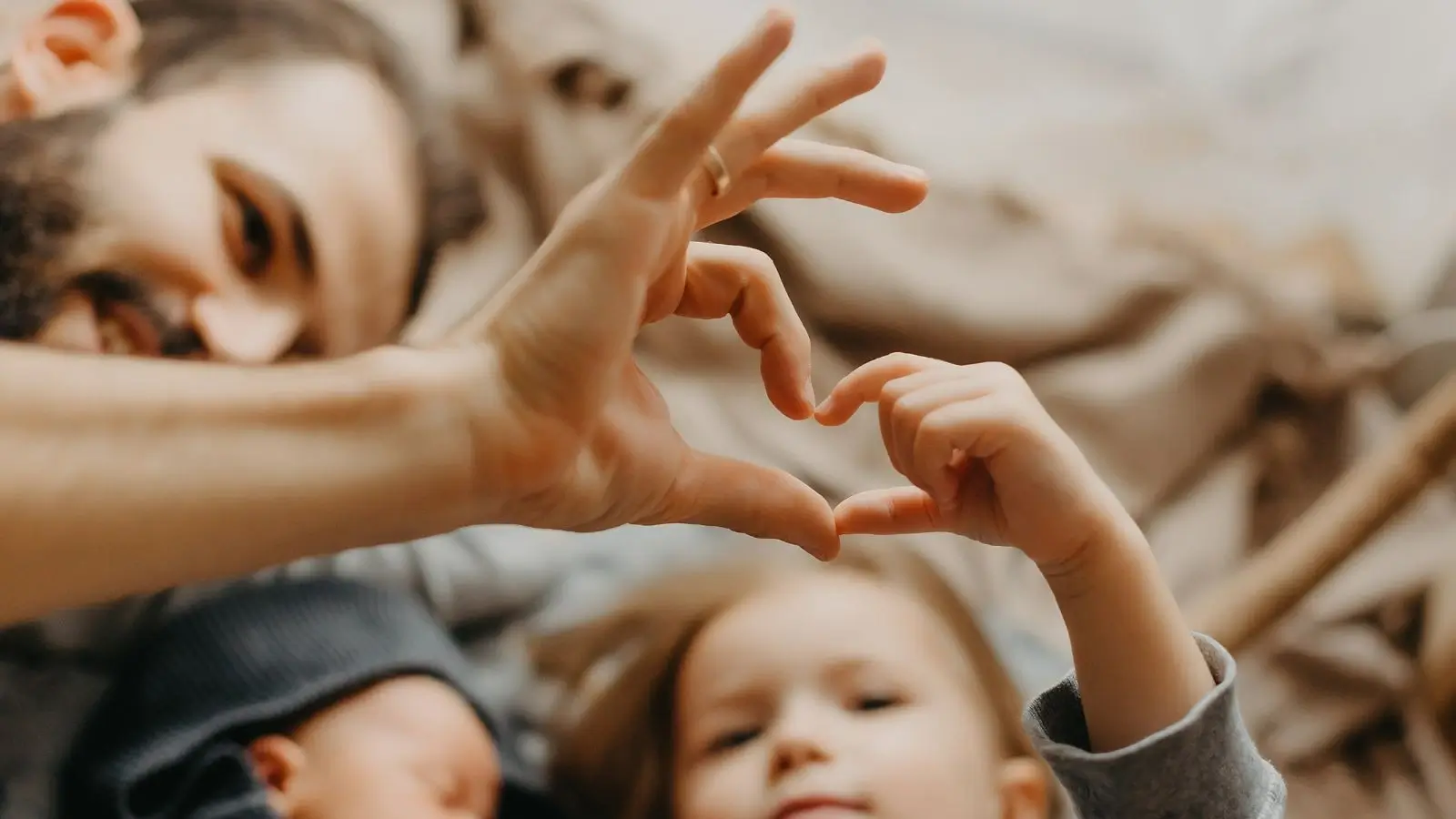 A father and a daughter putting their hands together forming a heart