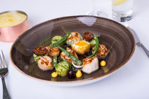A plate of scallops and veg
