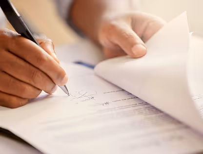 A man writes in a notebook.
